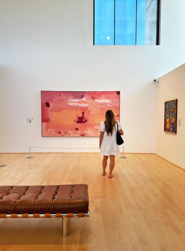 woman stands looking at art in the Hunter